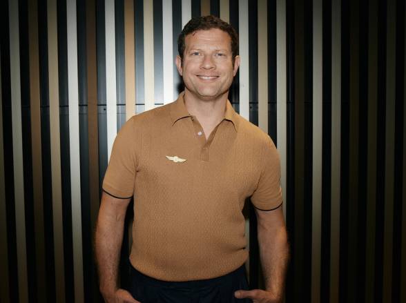 Dermot O'Leary in front of a striped background.