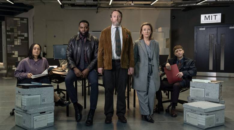 Izuka Hoyle, Dipo Ola, David Mitchell, Dorothy Atkinson, Gerran Howell looking seriously at the camera in a room with boxes filled with paperwork