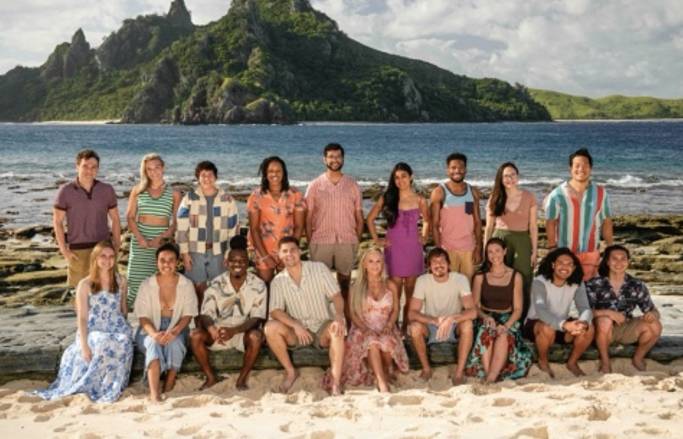 Survivor Season 47 Castaways Lined Up on a Beach with an island in the background.